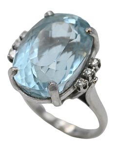 14 Karat White Gold Ring, set with large blue topaz, flanked by three diamonds on either side, size 7 1/4, 14.5 x 20.7 millimeters.