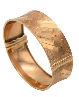14 Karat Gold Bangle Bracelet, having brush and stars designs, 61 millimeter interior, 29 grams.