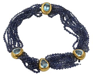 Eight Strand Necklace, having light purple beads, three 14 karat gold centers, each having teardrop blue topazes, along with oval topaz in clasp, topa
