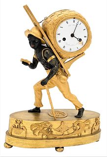 French Gilt Bronze Blackamoor Figural Silk Thread Clock, modeled as a young black man walking with a cane in one hand and carrying a basket with a bun
