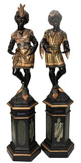 Pair of Large Polychrome Painted and Parcel Gilt Wood Blackamoor Figures on Stands, each male and female standing figure wearing painted and gilt garb
