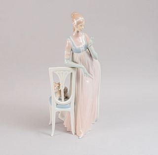 Dama con silla y perro. España, SXX. Elaborada en porcelana Lladró. Acabado brillante. 17 cm de altura.