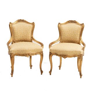 Par de sillones. SXX. Estilo Luis XV. Elaborados en madera tallada y dorada. Respaldo semiabierto con asiento en tapiceria textil