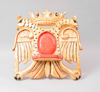 Atril de mesa. México, SXX .Talla en madera dorada. Decorado con águila bicéfala cononada y medallón rojo. 40 x 50 cm.