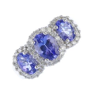 An 18ct gold tanzanite and diamond triple cluster ring. The slightly graduated oval-shape tanzanite