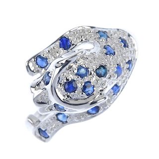 A 9ct gold sapphire and diamond leopard ring. Set with circular-shape sapphire and a single-cut diam