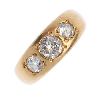 A diamond three-stone ring. The graduated circular-cut diamond line, inset to the tapered band. Esti