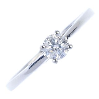 A 9ct gold diamond single-stone ring. The brilliant-cut diamond, to the tapered shoulders and plain