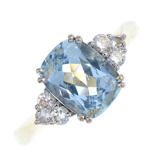 An 18ct gold aquamarine and diamond dress ring. The cushion-shape aquamarine, with brilliant-cut dia