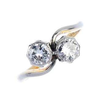 A mid 20th century 18ct gold diamond two-stone ring. The circular-cut diamond collets, to the asymme