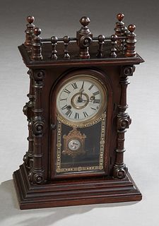 American Carved Mahogany "Gerster" Mantel Clock, 19th c., by E. N. Welch Co., the spindled crest over a time and strike clock, flanked by engaged turn