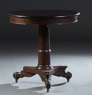American Classical Carved Mahogany Lamp Table, 19th c., the rounded stepped circular top over a wide skirt on ring turned tapered cylindrical supports
