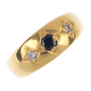 A diamond and sapphire band ring. The circular-shape sapphire and brilliant-cut diamond sides, each