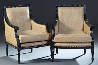 Pair of Louis XVI Style Ebonized Beech Bergeres, 20th c., the lappet carved crest rail over a rectangular back and reeded scrolled arms to a bowed sea
