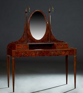 French Art Deco Carved Walnut Dressing Table, 20th c., the oval swiveling beveled glass mirror flanked by reeded engaged columns issuing two arched br