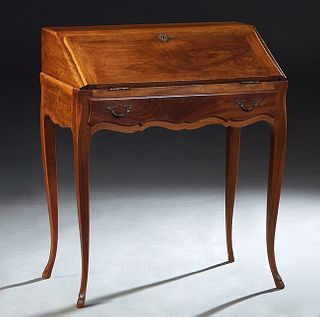French Carved Louis XV Style Walnut Slant Front Desk, early 20th c., rectangular back over a slant lid with an inset gilt tooled ocher leather writing