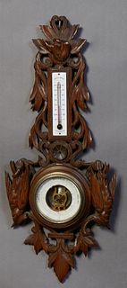 French Carved Walnut Aneroid Barometer, early 20th c., the top with a relief hunting dog carving over an enameled alcohol thermometer above an aneroid