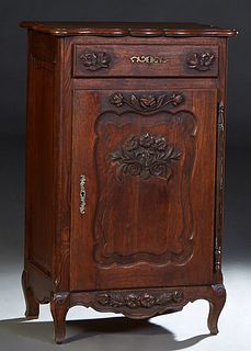 French Provincial Louis XV Style Carved Oak Confiturier, 19th c., the rounded edge serpentine top over a frieze drawer with a brass escutcheon, above 