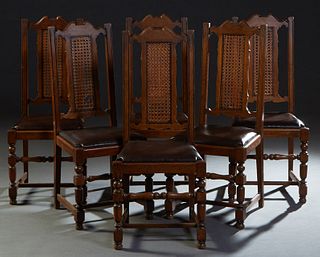 Set of Six Spanish Renaissance Style Carved Oak Dining Chairs, 20th c., the canted arched back over a central caned panel over a faux brown leather sl