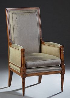 French Carved Walnut Louis XVI Style Bergere, early 20th c., canted high reeded upholstered back over upholstered arms and a removable cushion seat, o