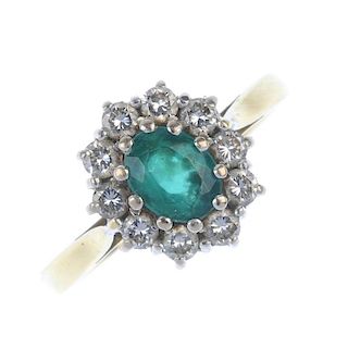 An 18ct gold synthetic emerald and diamond cluster ring. The oval-shape synthetic emerald, within a