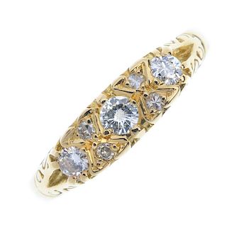 An 18ct gold diamond three-stone ring. The graduated brilliant-cut diamond line, with single-cut dia