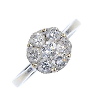 An 18ct gold diamond cluster ring. The brilliant-cut diamond, within a similarly-cut diamond raised
