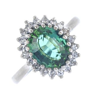A tourmaline and diamond cluster ring. The oval-shape green tourmaline, within a single-cut diamond