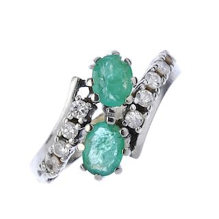 An emerald and diamond crossover ring. The oval-shape emeralds, to the brilliant-cut diamond crossov