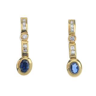 A pair of sapphire and diamond ear pendants. Each designed as an oval-shape sapphire collets, suspen