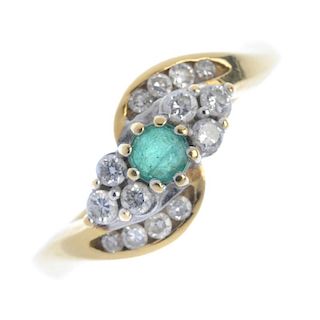 An 18ct gold emerald and diamond ring. The circular-shape emerald, to the brilliant-cut diamond tref