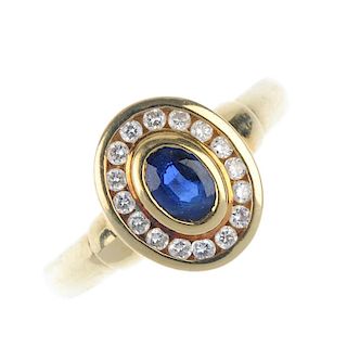 A sapphire and diamond cluster ring. The oval-shape sapphire collet, within a brilliant-cut diamond