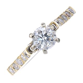 A diamond single-stone ring. The brilliant-cut diamond, to the similarly-cut diamond line sides and