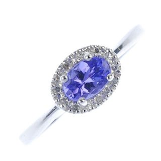 A 9ct gold tanzanite and diamond cluster ring. The oval-shape tanzanite, within a single-cut diamond