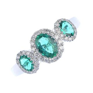 * An emerald and diamond triple cluster ring. The three oval-shape emeralds, each within a brilliant