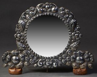 Mexican Sterling Mounted Mahogany Easel Mirror, mid 20th c., with a wide floral repousse border around a circular mirror plate, H.- 17 1/2 in., W.- 21