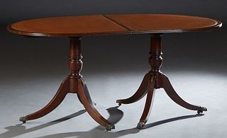 English Inlaid Mahogany Double Pedestal Dining Table, 20th c., the oval reeded edge top on turned urn form supports to tripodal brass mounted legs wit