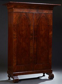 American Classical Gothic Carved Mahogany Armoire, 19th c., stepped ogee crown over two Gothic arched doors, on a plinth base with large scrolled feet