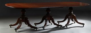 English Georgian Style Carved Mahogany Triple Pedestal Dining Table, 20th c., the oval reeded edge top on three turned vasiform supports with four ree
