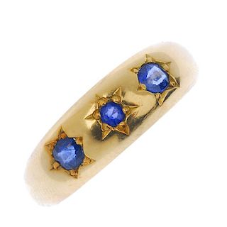 A sapphire three-stone ring. The circular-shape sapphire stars, inset to the tapered band. Weight 3.