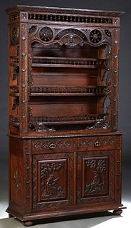 French Provincial Carved Oak Vaisselier, 19th c, Brittany, the incised ogee crown over a spindled rail above spindled wheel panels, flanking a spindle