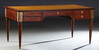 French Carved Mahogany Ormolu Mounted Louis XVI Style Desk, early 20th c., the rounded edge rectangular top with an inset gilt tooled ocher leather wr