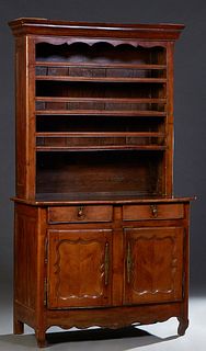 French Provincial Carved Walnut Vaisselier, 19th c., the stepped ogee top over three plate racks on a rounded corner base with two frieze drawers abov