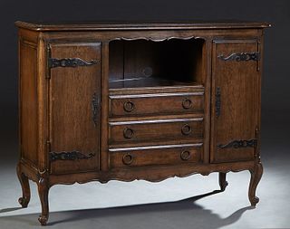 French Louis XV Style Carved Oak Sideboard, early 20th c., the stepped rounded corner top over central open storage above a bank of three drawers flan