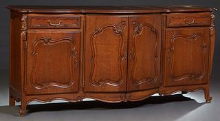 French Provincial Louis XV Style Carved Oak Sideboard, early 20th c., the parquetry inlaid serpentine stepped bowfront top over double central fielded