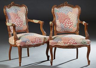 Pair of French Carved Walnut Louis XV Style Fauteuils, early 20th c., scroll carved crest rail over an upholstered shield shaped back, to upholstered 