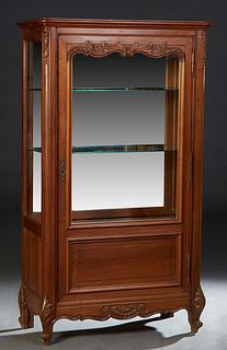 French Provincial Louis XV Style Carved Walnut Vitrine, c. 1900, the stepped rounded edge crown over a door with a wide beveled glass upper panel abov