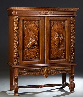 Spanish Renaissance Style Carved Oak Silver Cabinet , with double high relief game bird carved doors flanked by fruit and nut carved pilasters on a ba