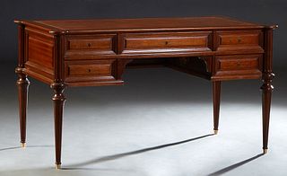 French Louis XVI Style Carved Mahogany Desk, 20th c., the cookie corner top with an inset gilt tooled brown leather writing surface over a frieze draw