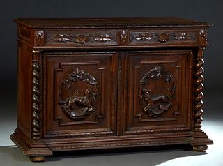 French Henri II Style Carved Oak Sideboard, c. 1880, the stepped carved edge top over two frieze drawers and two setback cupboard doors with high reli